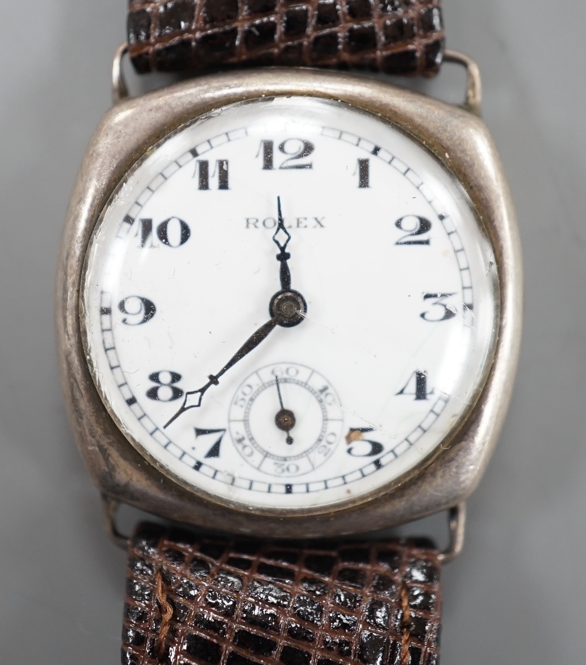 A gentleman's 1920's silver wrist watch, with Arabic dial and subsidiary seconds, the dial signed Rolex, movement unsigned, lacking winding crown.